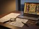 Photographic macro scene: a golden book prop and a scarab amulet on a tidy