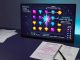 Photographic studio shot of a modern desk with a monitor showing a Starburst-style slot